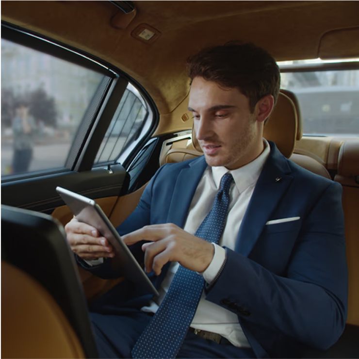 Business executive using mobile phone while sitting comfortably in luxury vehicle interior